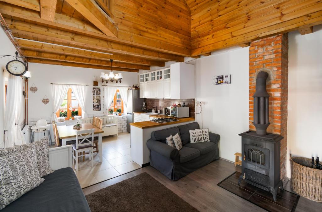 a living room with a stove and a kitchen at HepeHuta Házikó in Háromhuta