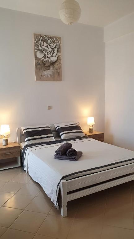a bedroom with a large white bed with two lamps at Blue Bay Apartment in Chania