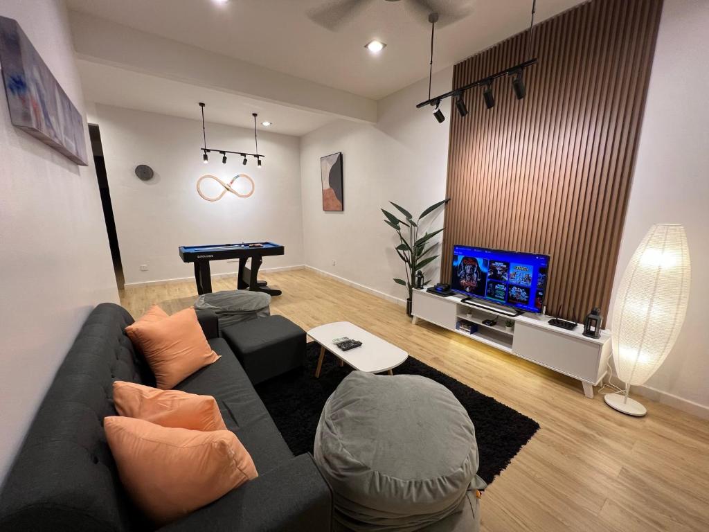 sala de estar con sofá gris y TV en Mujito 8PAX NearTC, DinosaurLand, PoolTable, PS4, en Kuantan