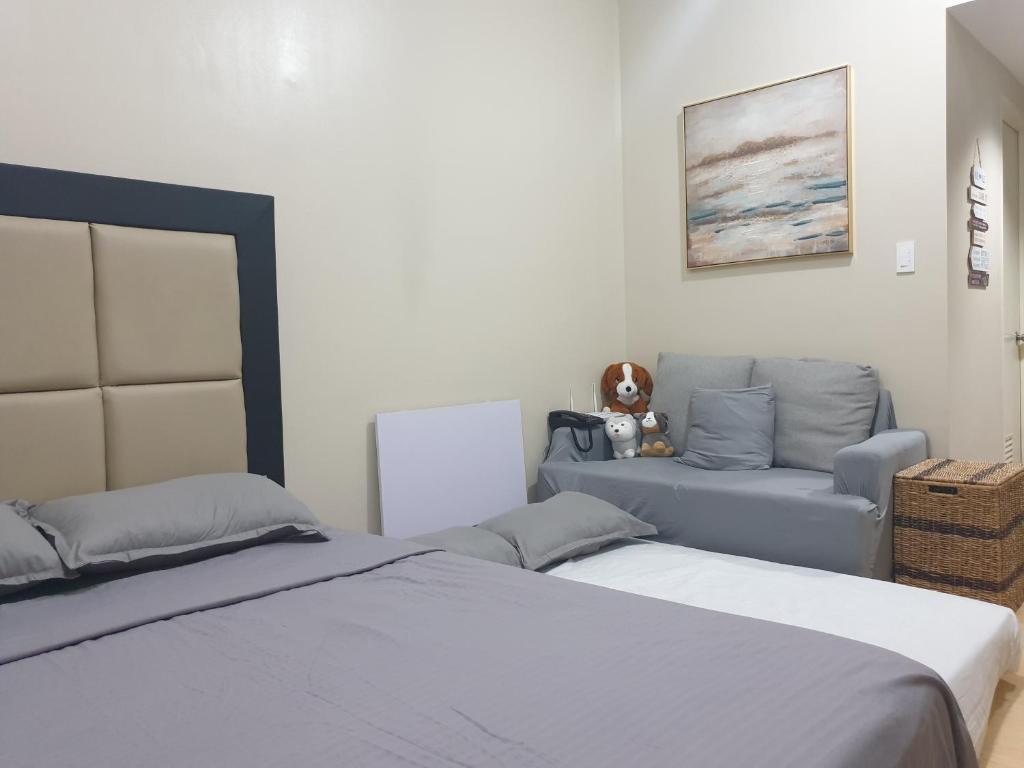 a bedroom with two beds and a couch at CunduNiAia Sunvida Tower Condominium Unit Across SM Cebu in Cebu City