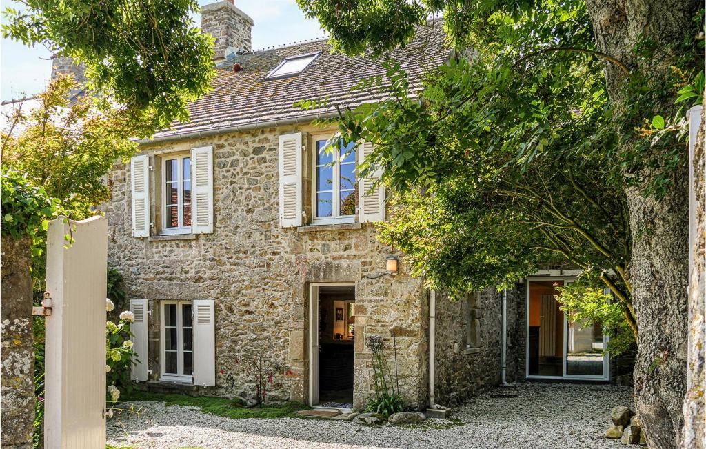 an exterior view of a stone house with trees at 3 Bedroom Nice Home In St Germain Des Vaux in Auderville