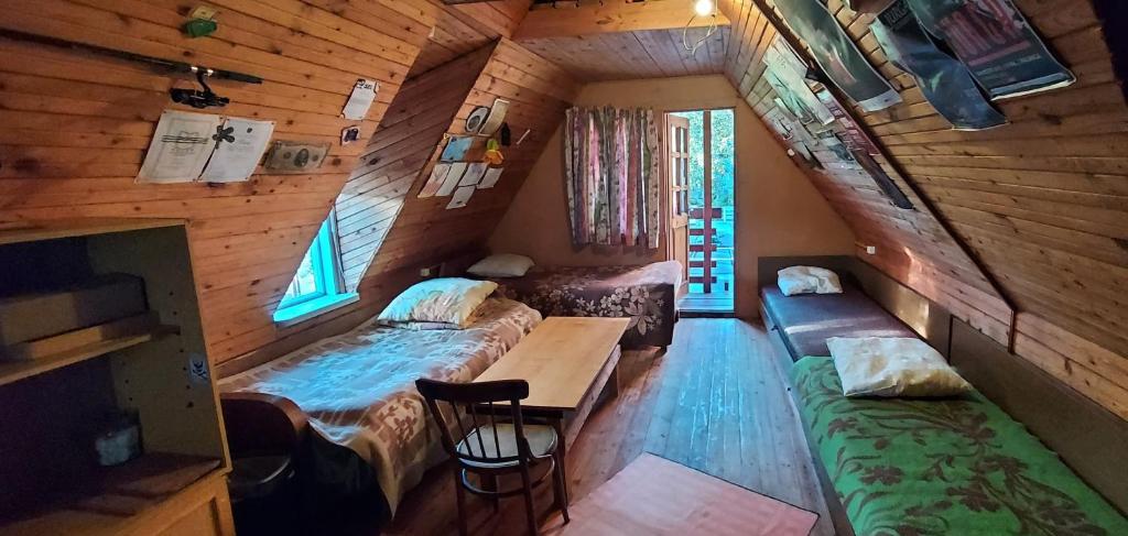 a room with two beds and a table in a cabin at Studentiški apartamentai Palangoje in Palanga
