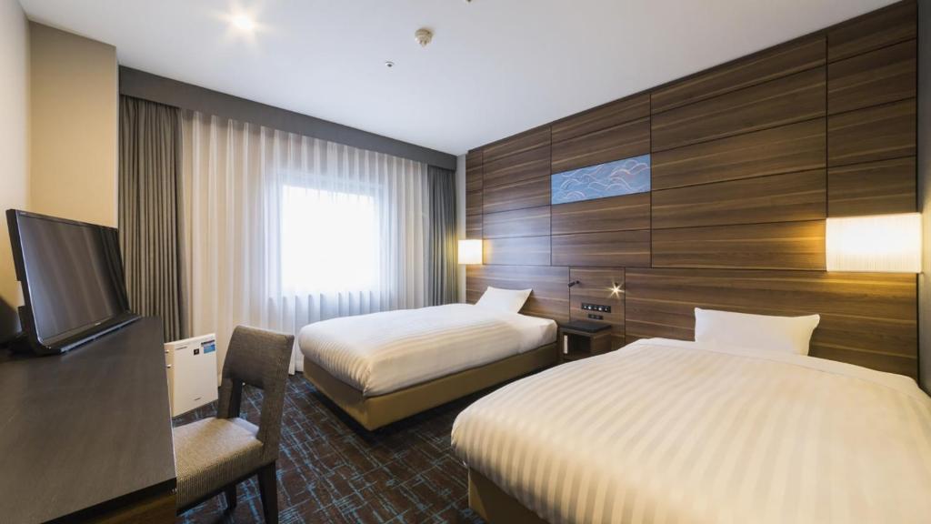 Postel nebo postele na pokoji v ubytování JR-East Hotel Mets Tsudanuma