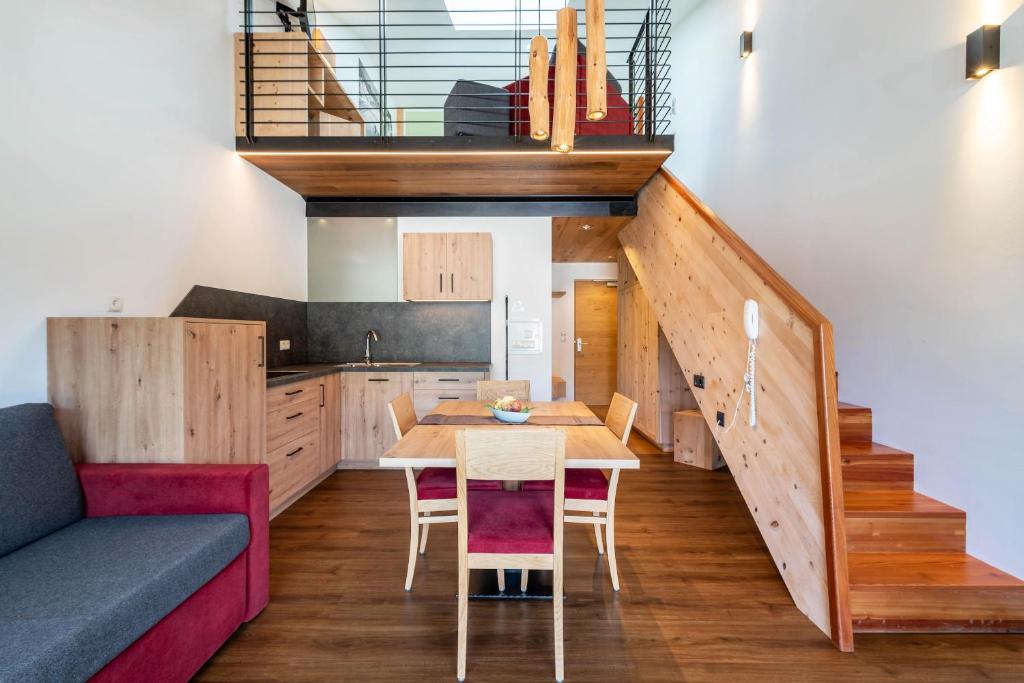 una cucina e una sala da pranzo con tavolo e scala di Hohenegg Apartment Franz 2 a Campolasta
