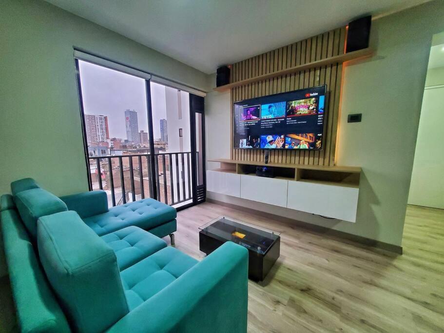 sala de estar con sofá azul y TV de pantalla plana en Apartamento estreno céntrico y moderno, en Lima
