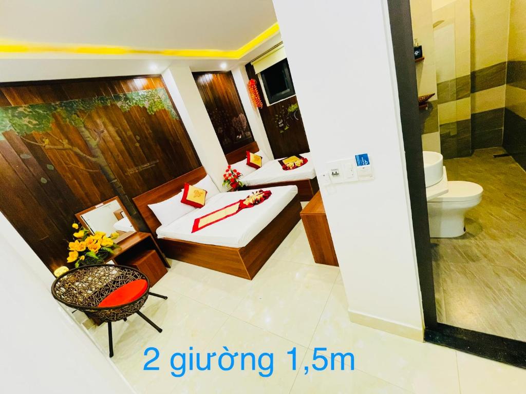 フエにあるNgọc Bích Home Huếのベッド2台とトイレが備わる客室です。