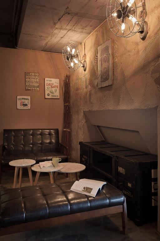 a living room with a leather couch and tables at Ximen Wow Hostel in Taipei