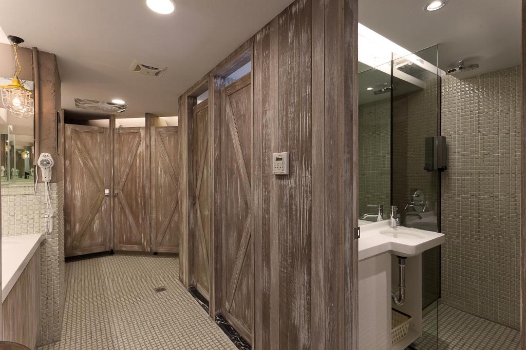 a bathroom with a shower and a sink and a mirror at Ximen Wow Hostel in Taipei