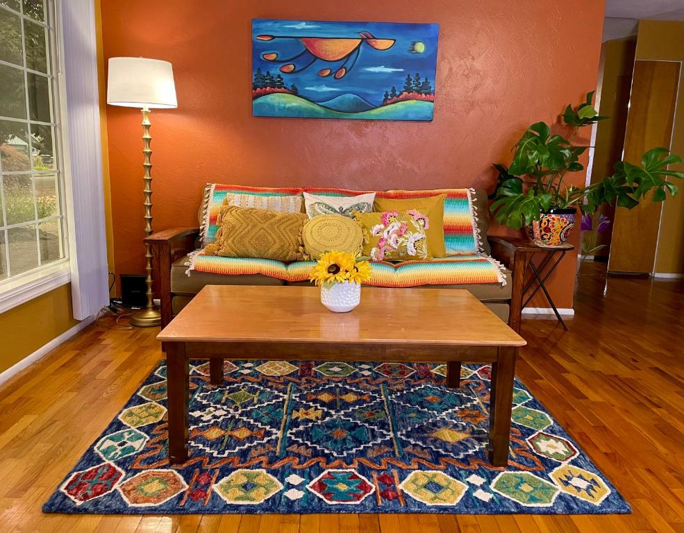 uma sala de estar com um sofá e uma mesa de centro em Welcome! Colorful 50's Ranch in the Heart of Eugene em Eugene