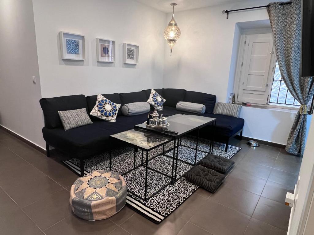 a living room with a black couch and a table at Sueños de la Alhambra in Granada