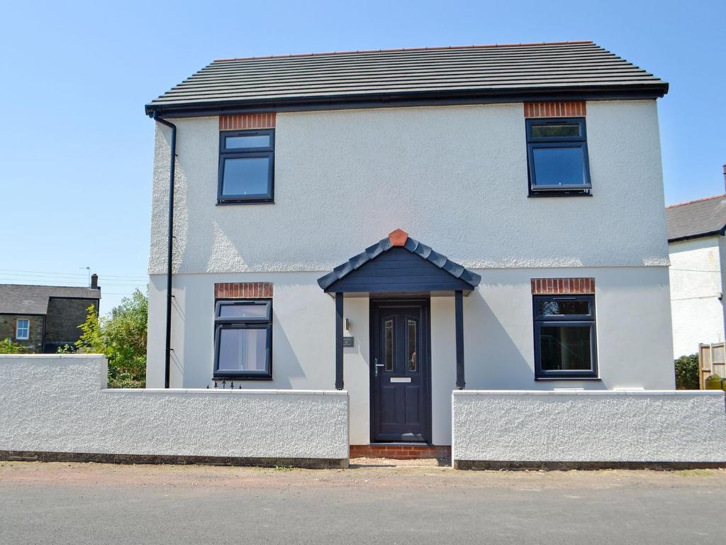 a white house with a black door and windows at Forest Walk in Coleford