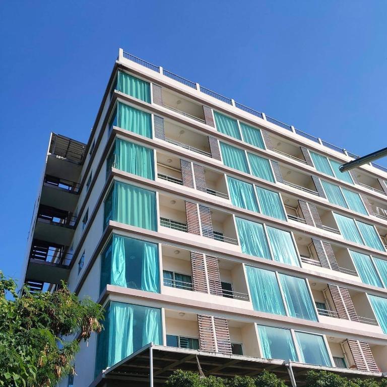a tall apartment building with green and white windows at Chiangmai residence in Chiang Mai