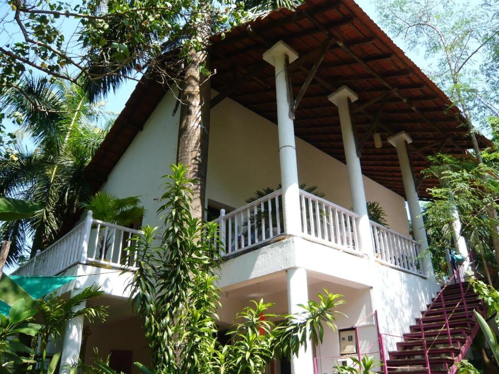 a house with a balcony on the side of it at Michèle's Garden in Anjuna