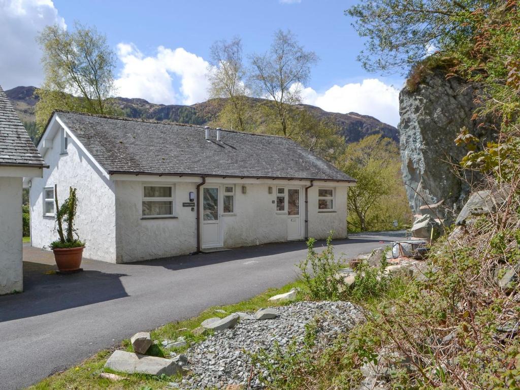 a white house with a mountain in the background at Langdale Cottage in Chapel Stile