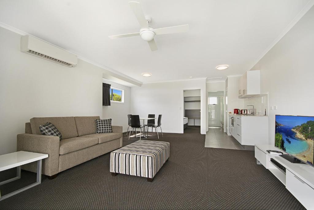 a living room with a couch and a table at Cooroy Luxury Motel Apartments in Cooroy