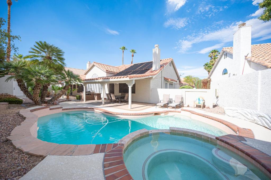 a swimming pool in front of a house at Delightful 4 Bedroom House with Pool! in Las Vegas