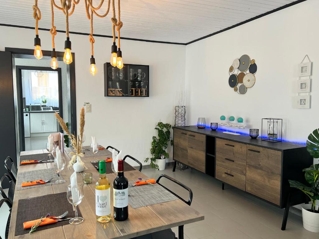 a dining room with a table with wine bottles on it at Le Clos fleuri in Fauvillers
