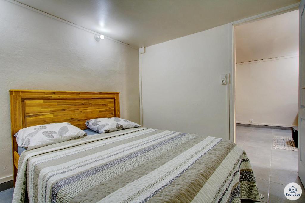 - une chambre avec un lit et une tête de lit en bois dans l'établissement Mauricia - Maison - 77m2 - Saint-Benoit, à Saint-François