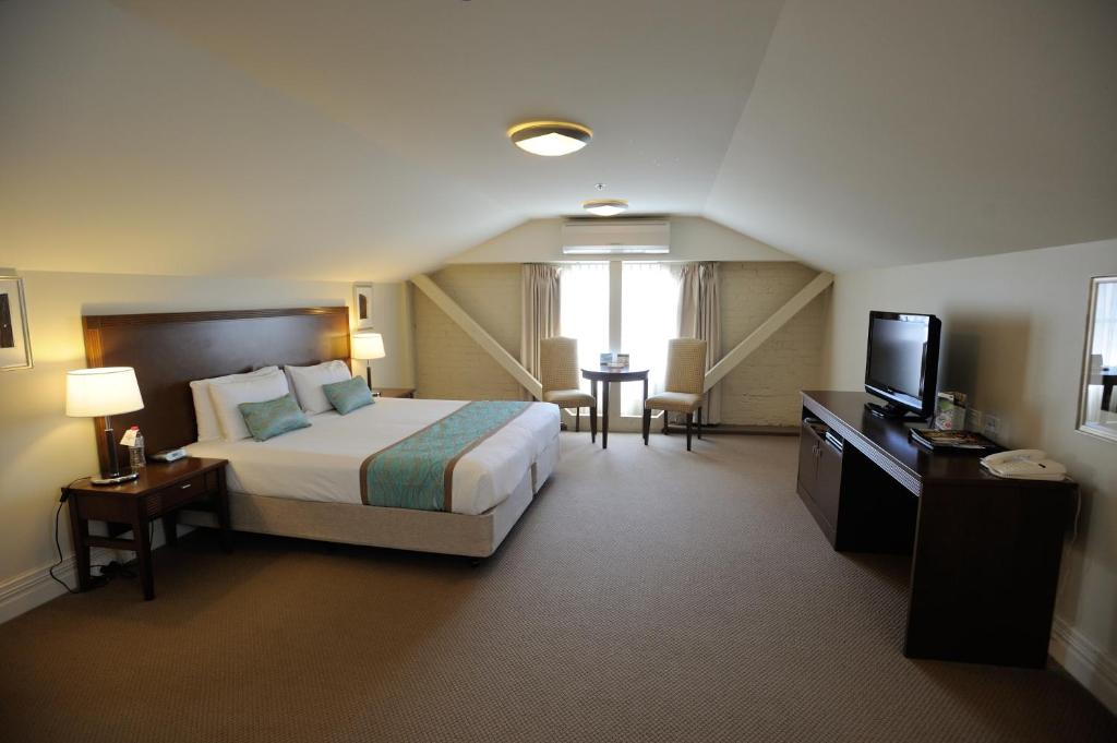 a hotel room with a bed and a television at Launceston Central Apartment Hotel Official in Launceston