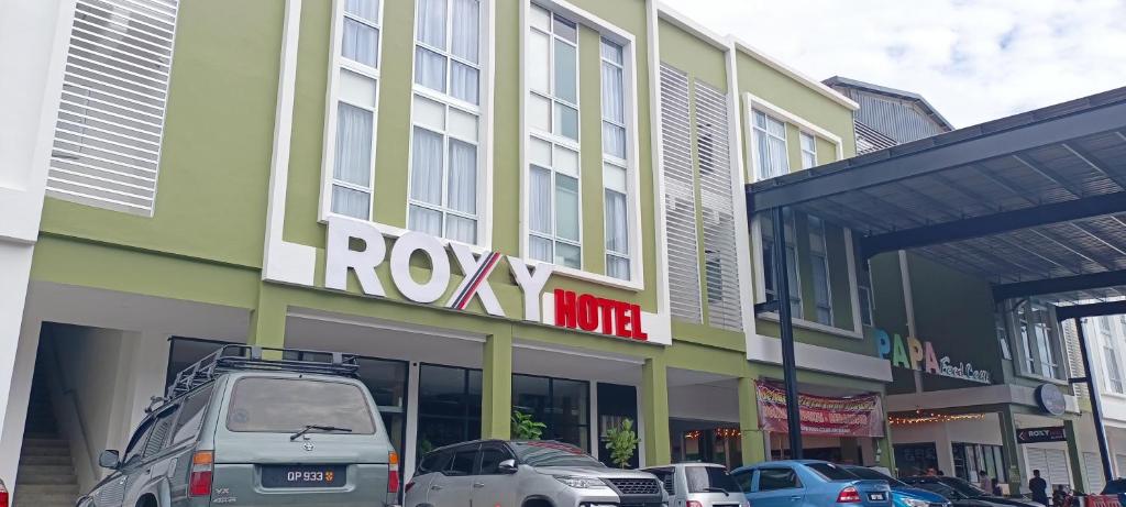 une rangée de voitures garées devant un bâtiment dans l'établissement Roxy Hotel Sri Aman, à Simanggang