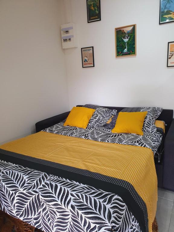 uma cama com almofadas amarelas em cima em ô Langevin , Logement avec véhicule em Saint-Joseph