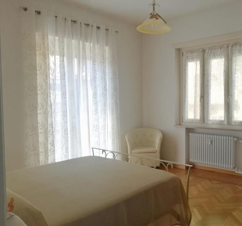 1 dormitorio con 1 cama, 1 silla y 1 ventana en Casa Fresia, en Turín