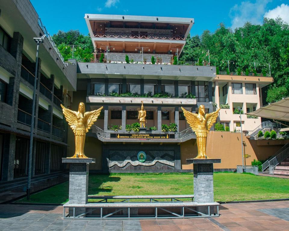 two gold statues in front of a building at Oro Montana Hotels and Resort in Bhurtuk