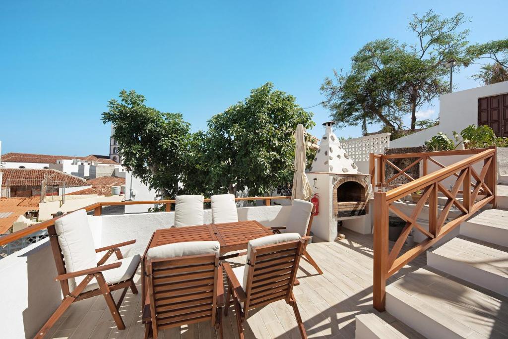 un patio con mesa, sillas y chimenea en Casa Sol 21 B Garachico, en Garachico