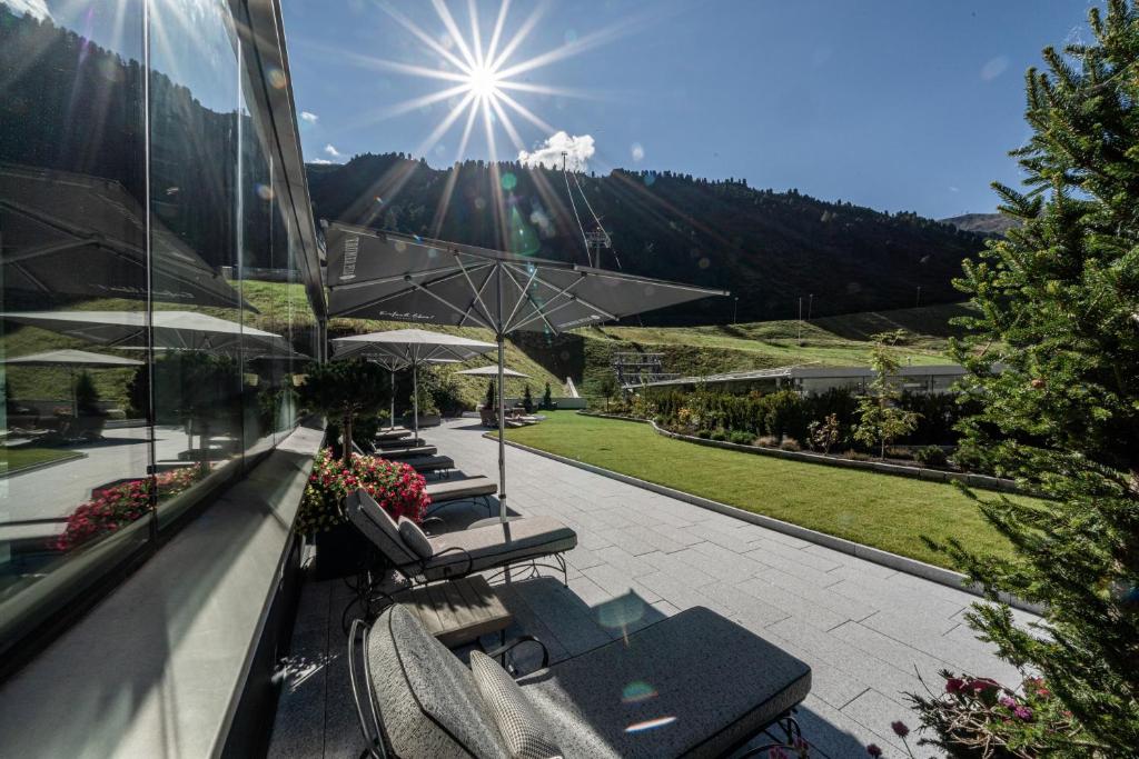 a view of a patio with chairs and umbrellas at Hotel Edelweiss & Gurgl in Obergurgl