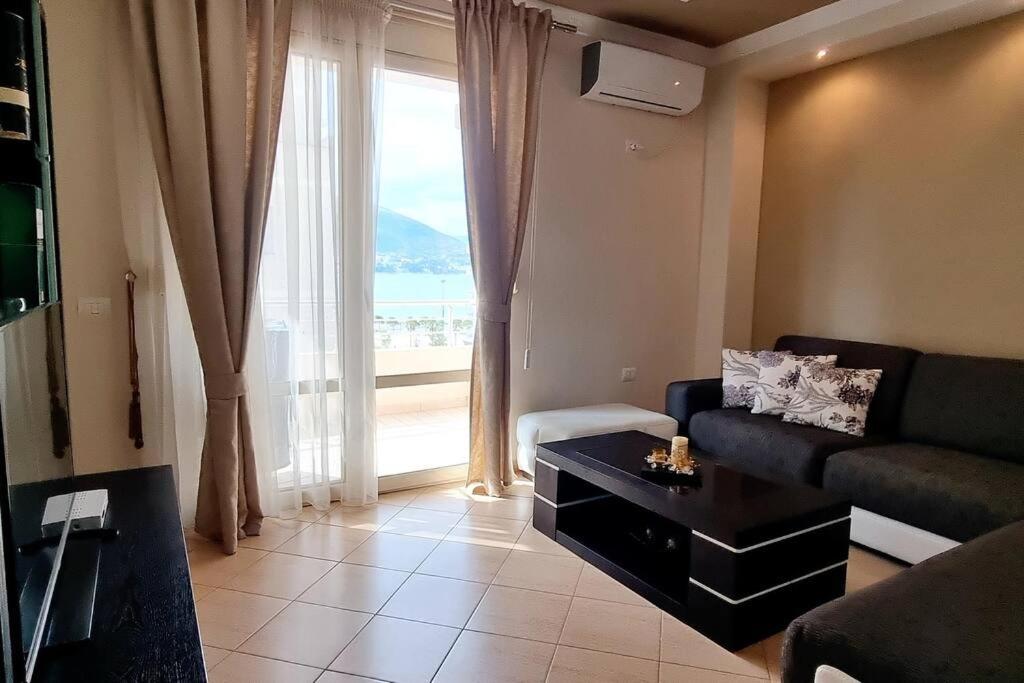een woonkamer met een bank en een groot raam bij Sea view apartment 105m² in Vlore in Vlorë