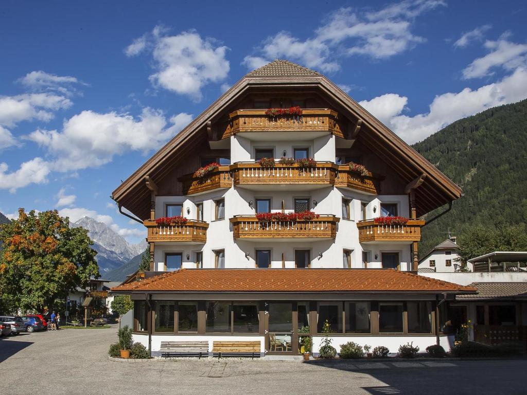ein großes Gebäude mit Balkonen darauf in der Unterkunft Schmalzlhof Hotel & Apartments in Oberrasen