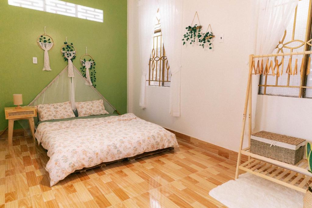 1 dormitorio con 1 cama en una habitación con paredes verdes en Phòng Mơ - Nhà Mơ Homestay Bến Tre, en Ben Tre