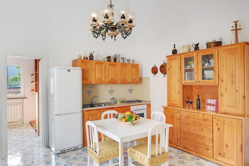 Il comprend une cuisine équipée d'une table blanche et d'un réfrigérateur blanc. dans l'établissement Casa Giuseppe by Gocce, à Sant'Agnello