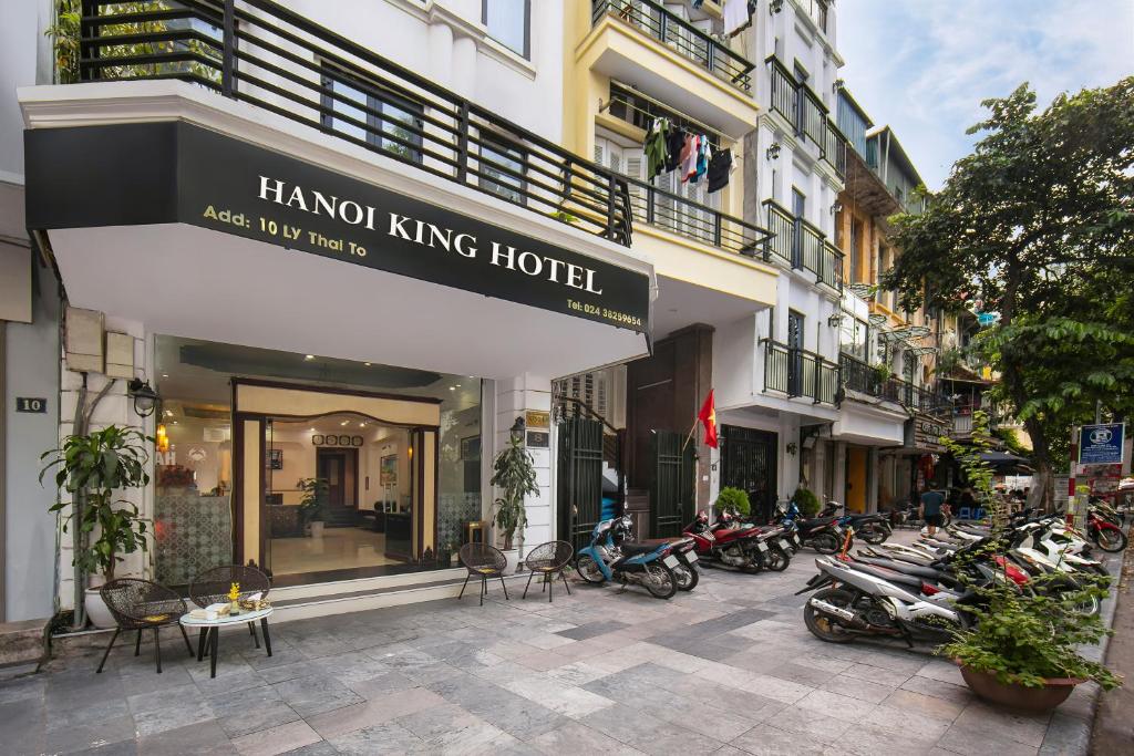 un gruppo di motociclette parcheggiato di fronte a un hotel di Hanoi Kingly Hotel a Hanoi