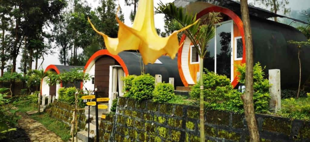 una casa con una gran escultura amarilla delante de ella en Tube Bromo Homestay en Probolinggo