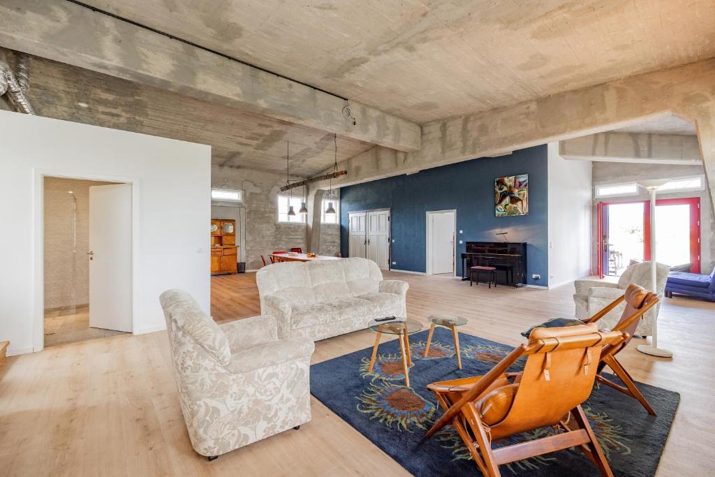 a living room with white furniture and a blue wall at Güterloft Altefähr in Altefähr