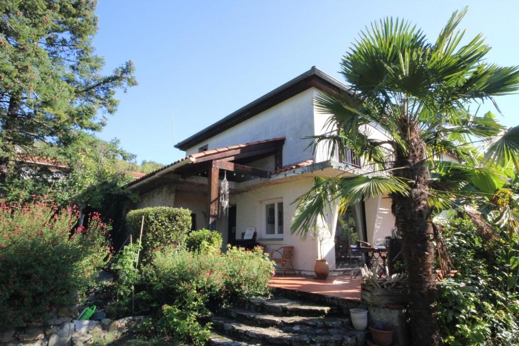 uma casa com uma palmeira em frente em Les chambres de Sophie em Chalabre