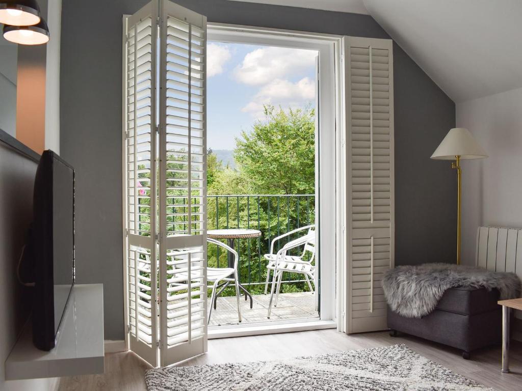 a room with a sliding glass door to a balcony at The Penthouse in Bowness-on-Windermere