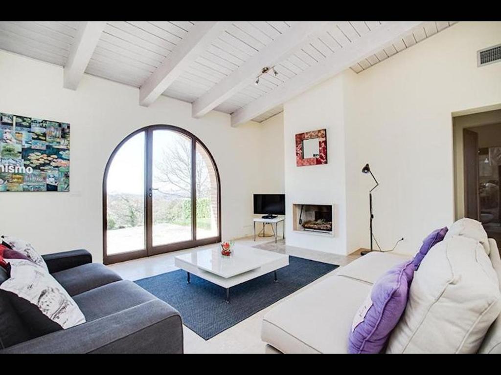 ein Wohnzimmer mit einem Sofa und einem Tisch in der Unterkunft Appartament Rosmarino - Cignella Resort in Osteria Delle Noci