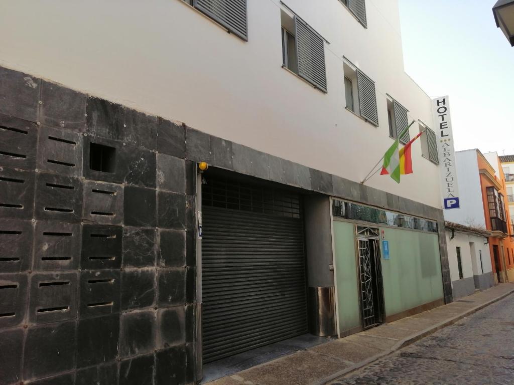 un edificio con una puerta de garaje al lado de una calle en La Albarizuela, en Jerez de la Frontera