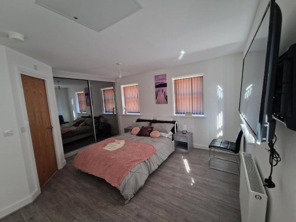 a bedroom with a bed and a flat screen tv at 7 Burnby Close,Leeds,LS14 1GA in Leeds