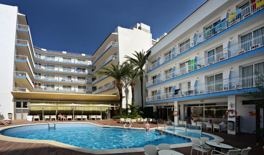 uma piscina em frente a um edifício em Hotel Miami em Calella