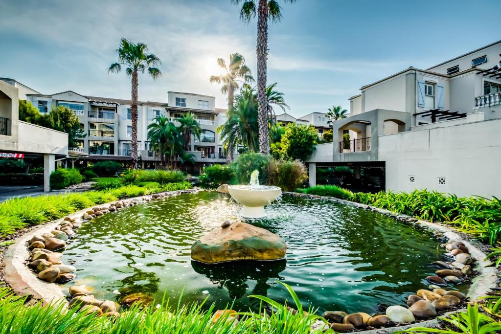 a fountain in a pond in front of condos at Belina - Bougain Villas Premier in Cape Town