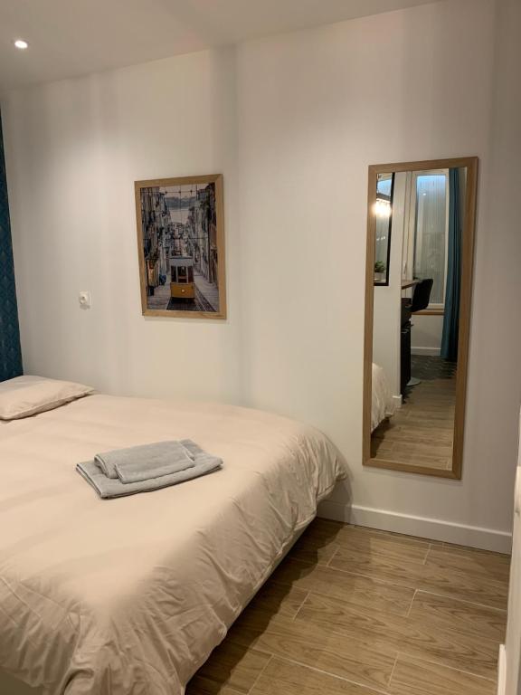 - une chambre avec un lit et un miroir dans l'établissement Le Studio Cosy, à Orléans