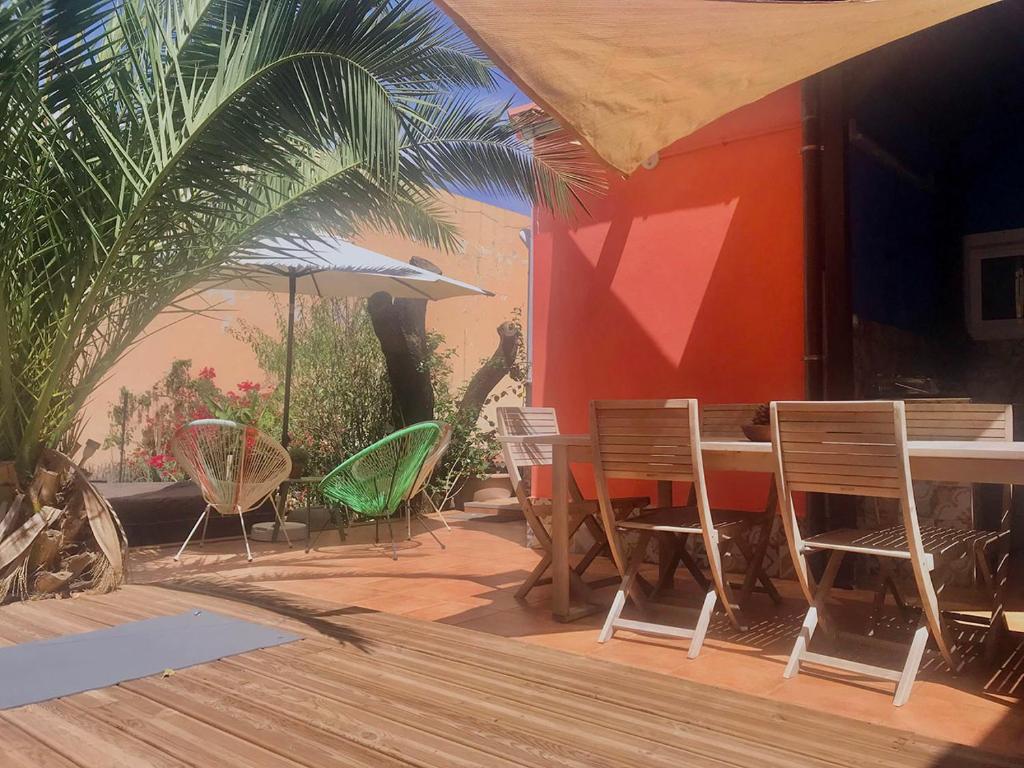 un patio con sillas, una mesa y una sombrilla en Casa VivaQi Tenerife, en Granadilla de Abona