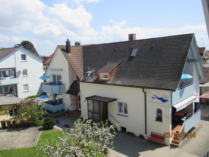 ein weißes Haus mit braunem Dach in der Unterkunft Ferien-und Gästehaus Wilma in Langenargen
