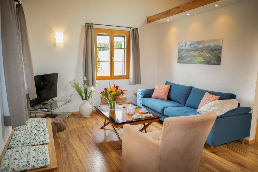 a living room with a blue couch and a table at Guesthouse La Moliere in Murist