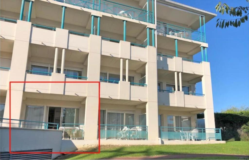 a large white building with a red line in front of it at Studio au calme avec piscine, face golf, parking gratuit, tout à pied à 10mn centre ville in Ciboure