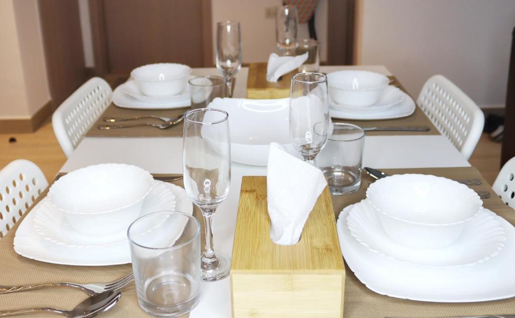 una mesa con platos blancos y vasos. en ZAPBED House - Luxury Holiday Homes in Yas Island en Abu Dabi
