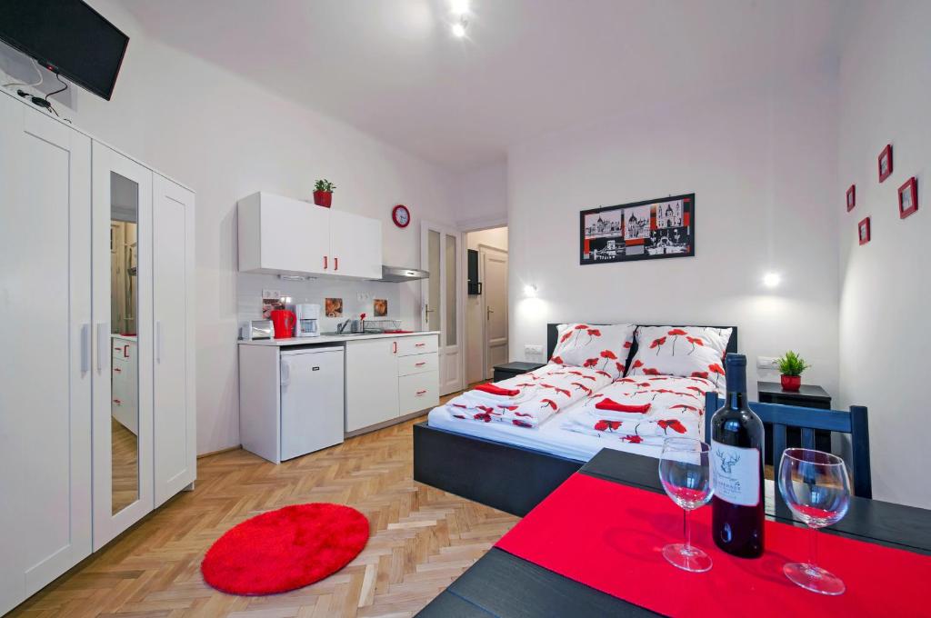 1 dormitorio con cama y mesa roja con copas de vino en PARKING, AC, WIFI FLAT NEXT TO ANDRASSY Ave, en Budapest